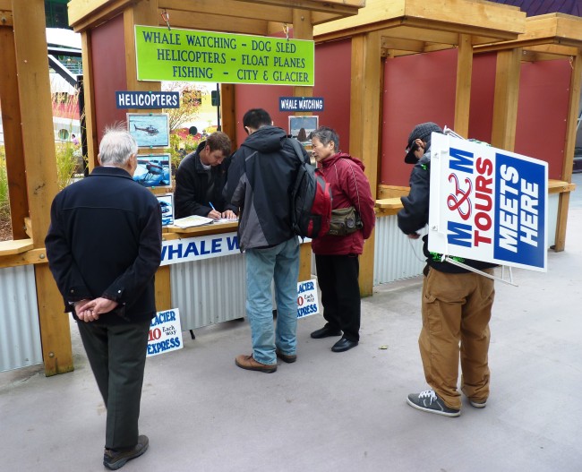 Tourists off the Norwegian Sun book a Mendenhall Glacier tour near Juneau's waterfront on one of the last days of 2014's tourism season. Passenger numbers were similar to last year's. (Ed Schoenfeld, CoastAlaska News)