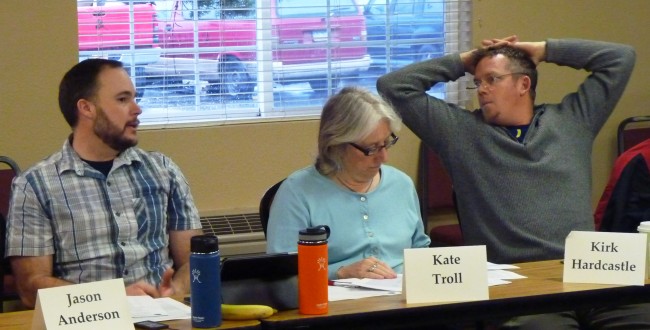 2-17-15 The Forest Service's Jason Anderson, left, talks with fisherman Kirk Hardcastle while Juneau Assemblymember Kate Troll reviews a report during the Tongass Advisory Committee meeting Feb. 17 in Juneau. (Ed Schoenfeld/CoastAlaska News)